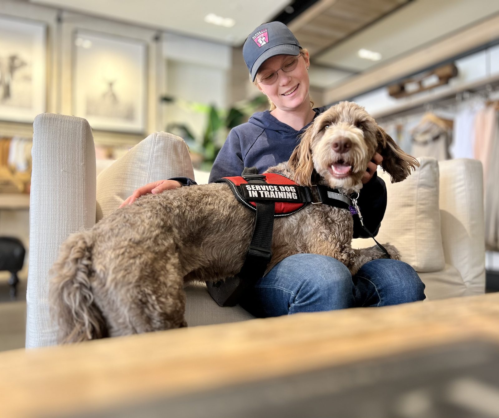 An AlphaDog trainer sharing a moment with a service dog in training during a public outing