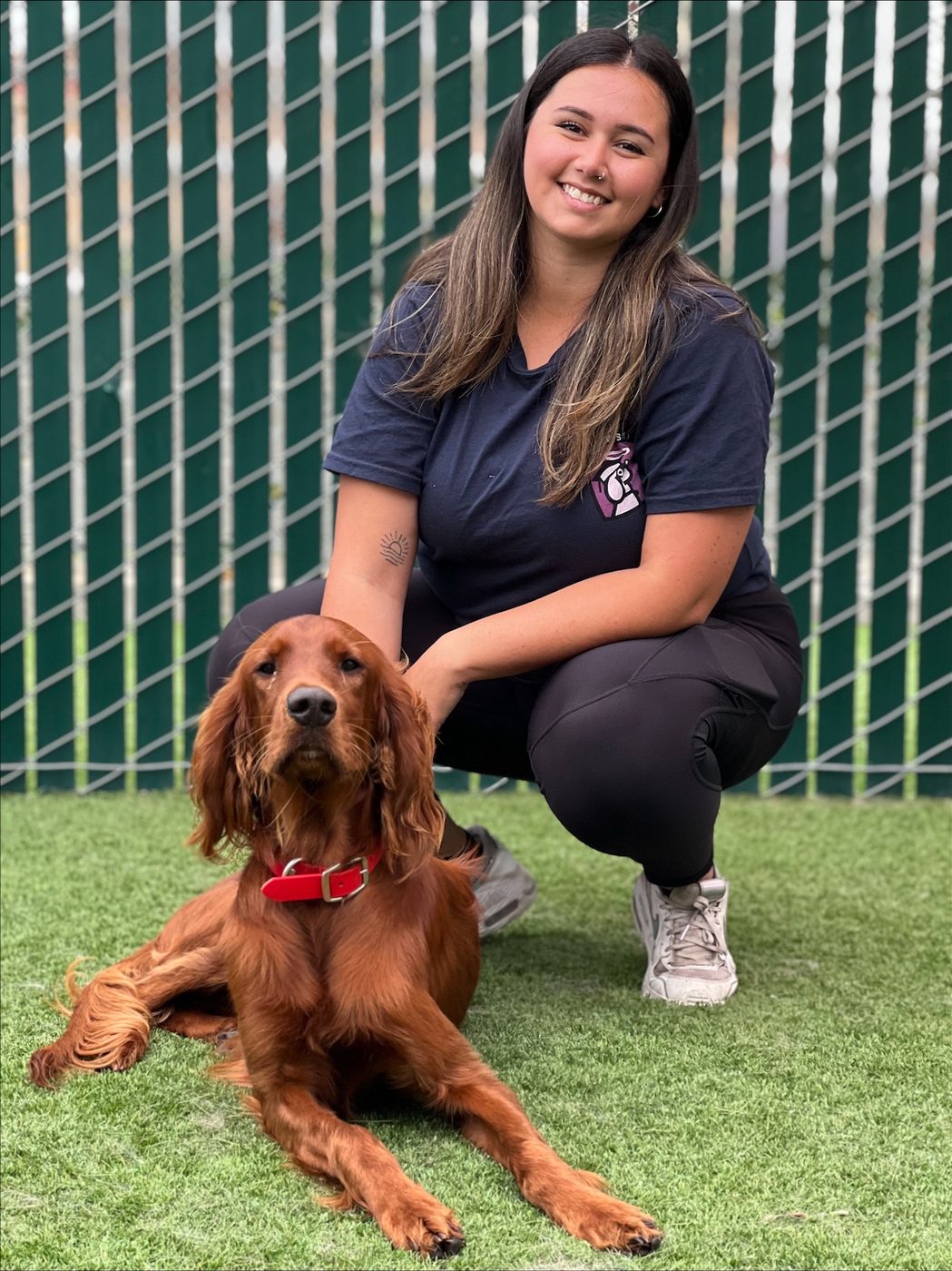 An AlphaDog team member with a dog in the yard