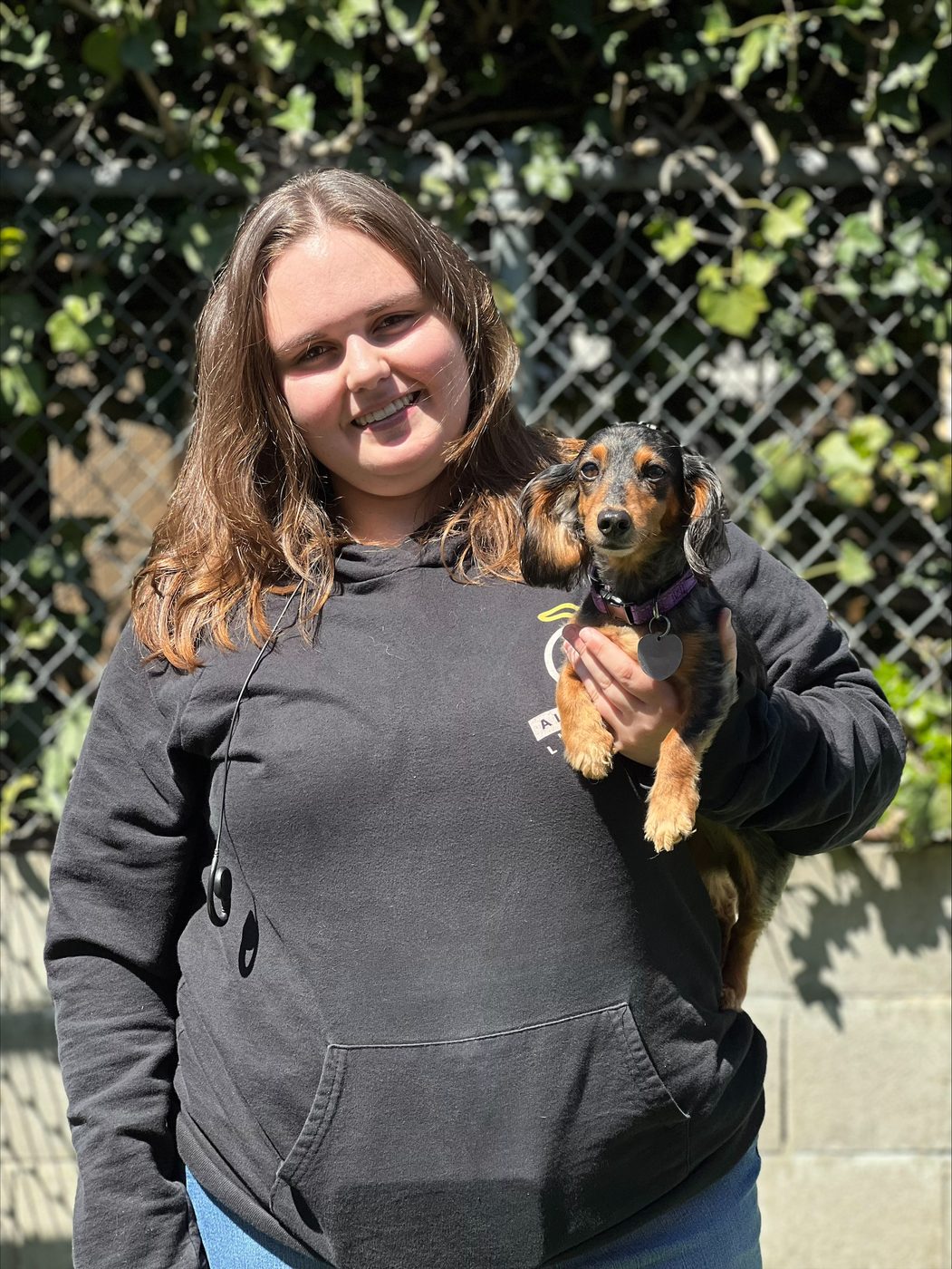 An AlphaDog team member with a dog in the yard
