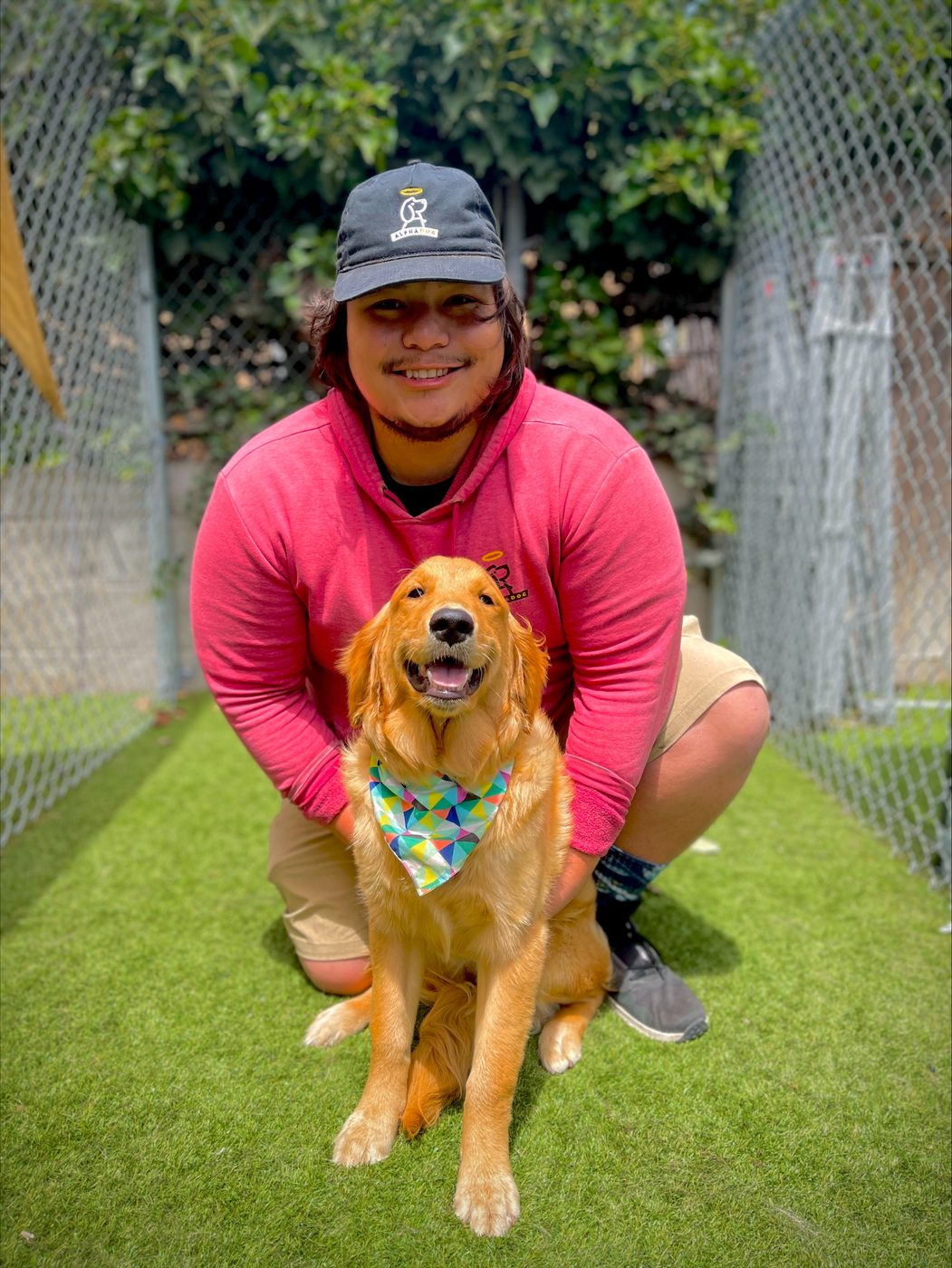 An AlphaDog team member with a dog in the yard