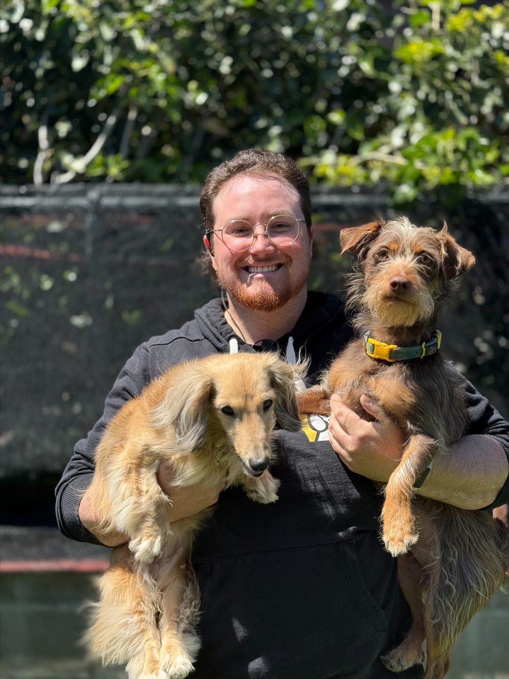 An AlphaDog team member with a dog in the yard