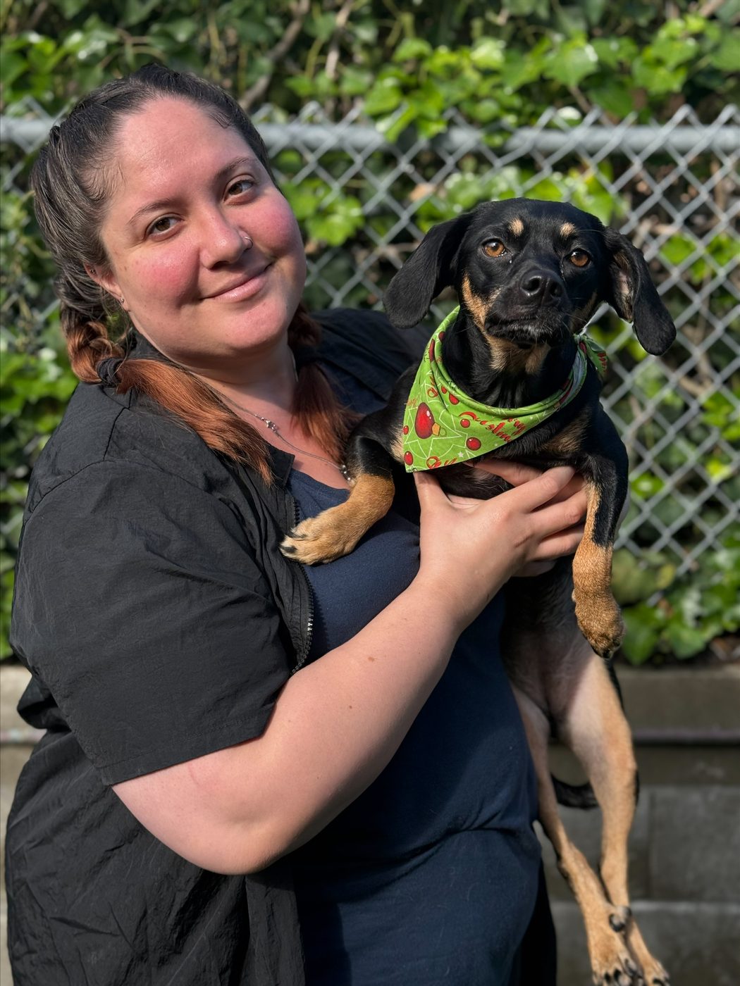 An AlphaDog team member with a dog in the yard
