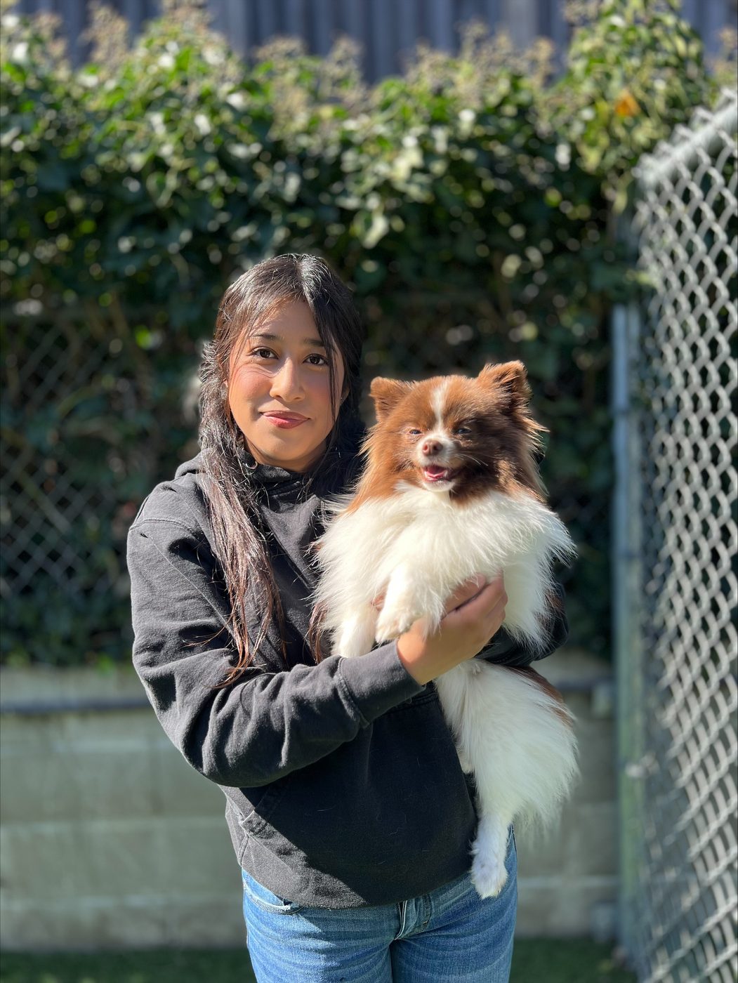An AlphaDog team member with a dog in the yard