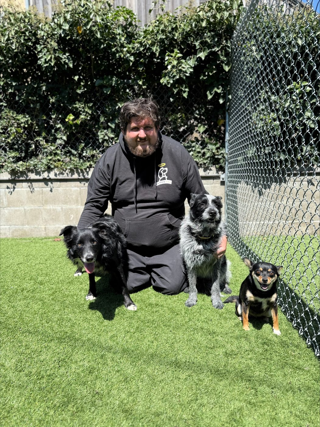 An AlphaDog team member with a dog in the yard