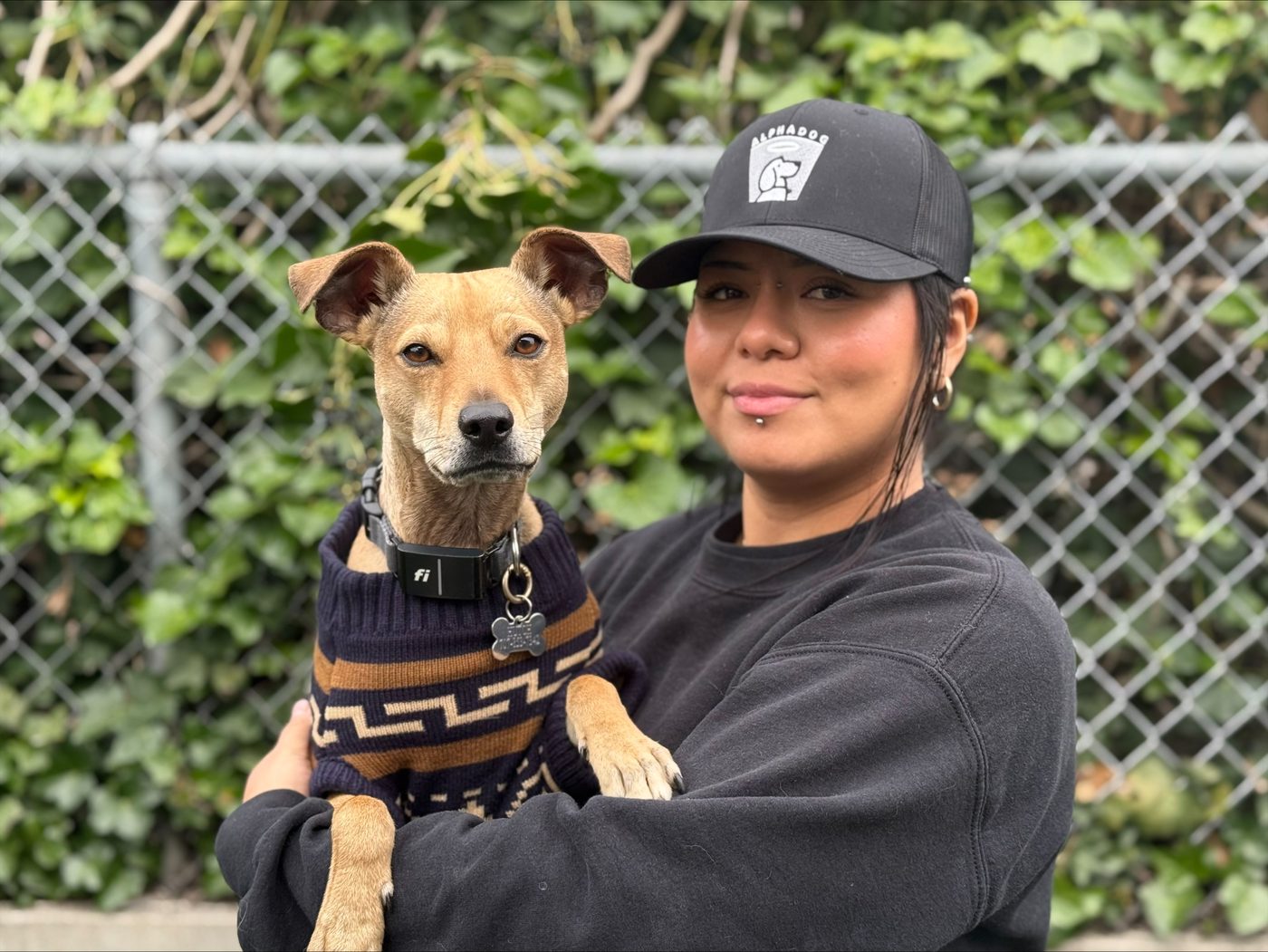 An AlphaDog team member with a dog in the yard