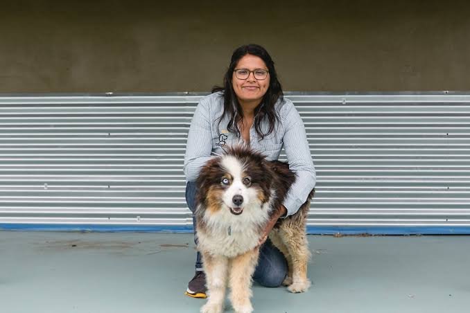 An AlphaDog team member with a dog in the yard
